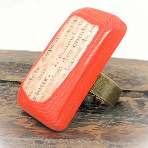 Bague en papier rouge fabriquée avec des pages d'un vieux livre et des feuille rouges