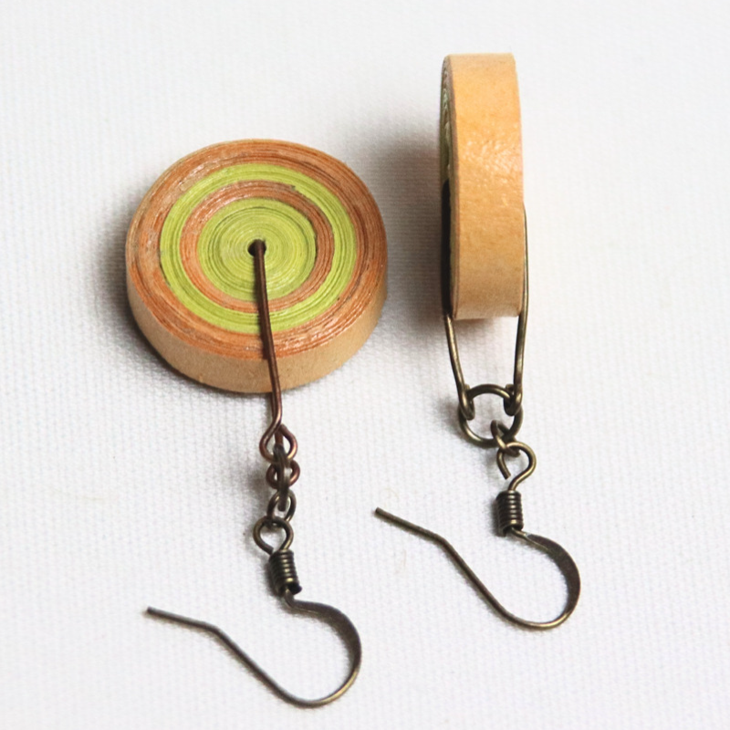 Boucles d'oreilles en papier jaunes et oranges de forme circulaire tel un disque de papier