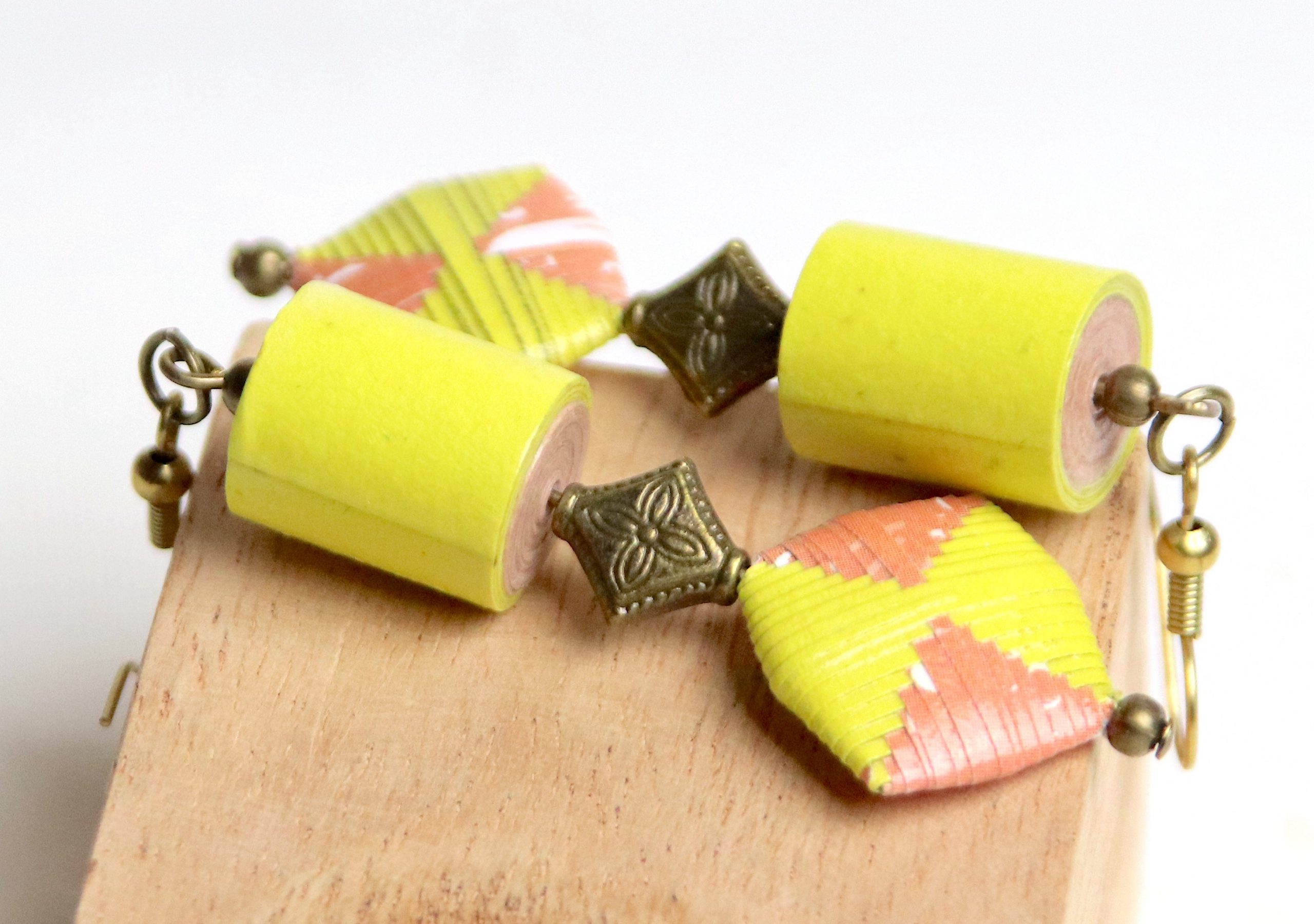 Boucles d'oreilles avec une perle roulée cylindrique et une perle pliée toutes les deux de couleur jaune et saumon et fabriquées en papier