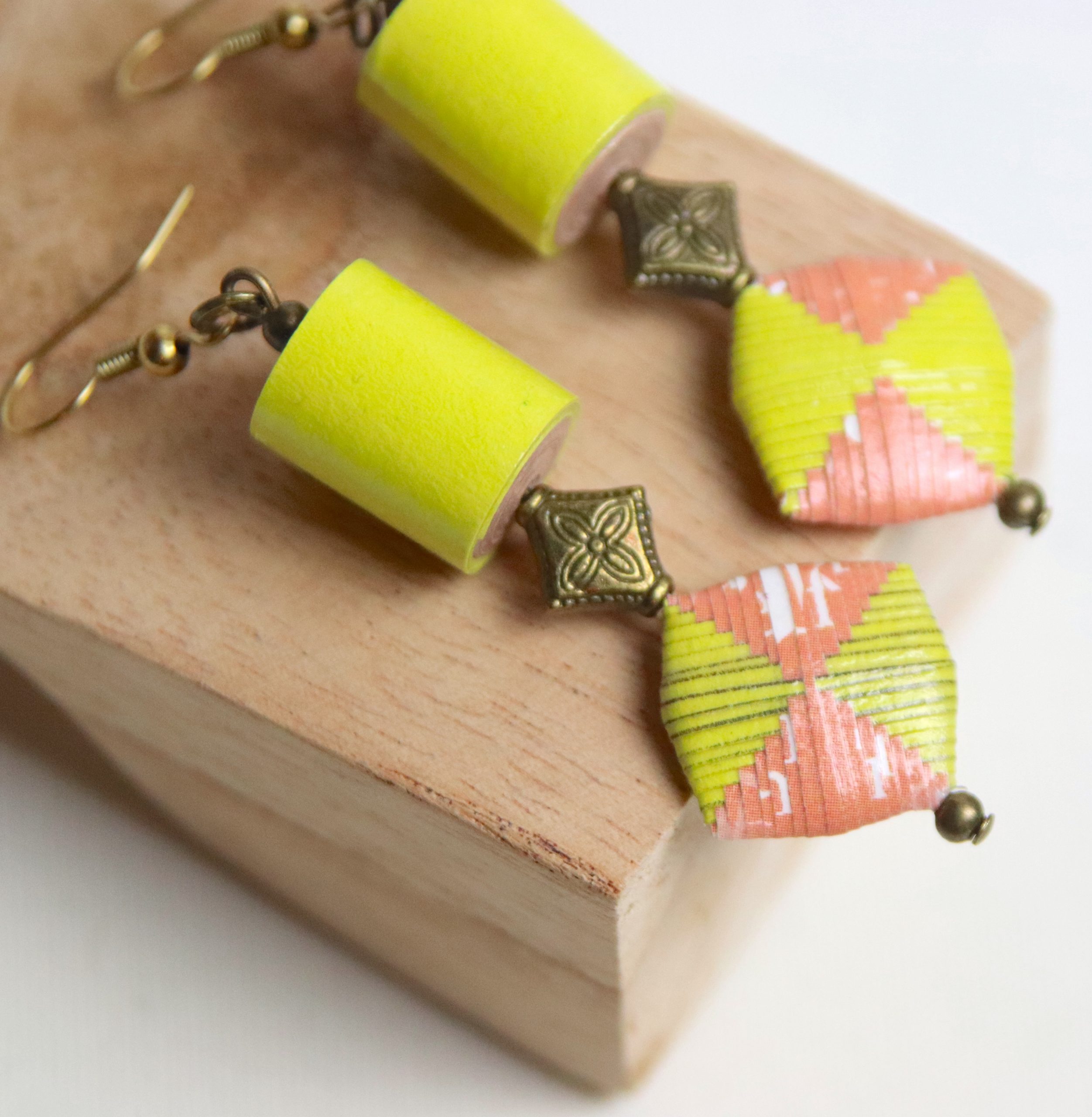 Boucles d'oreilles avec une perle roulée cylindrique et une perle pliée toutes les deux de couleur jaune et saumon et fabriquées en papier