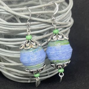 Boucles d'oreilles composées d'une grosse perle ronde en papier bleue et verte avec au dessus et au dessous un apprêt plat en forme de fleur